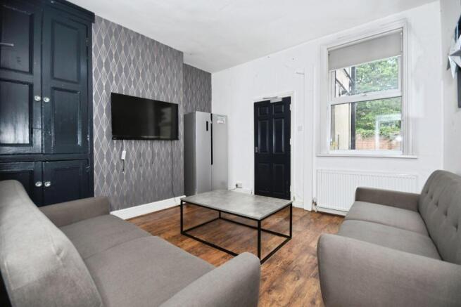 Bright communal living room with two matching s...