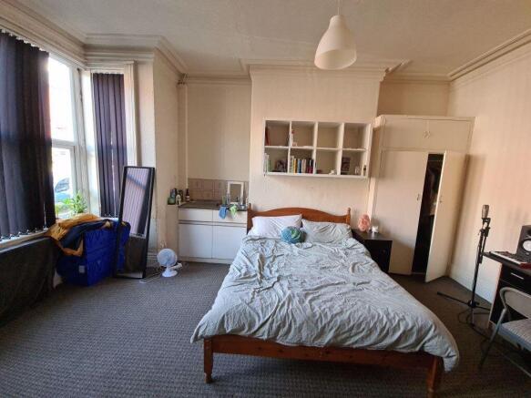 A spacious master bedroom with a double bed and...