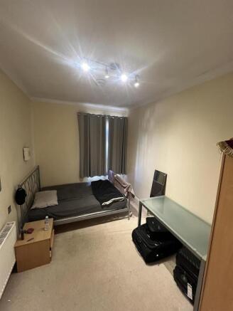 Spacious bedroom with a large desk and double b...