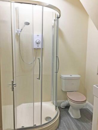 Bright, tidy bathroom featuring a curved-glass ...