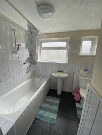 Bright bathroom featuring a full-sized bath...