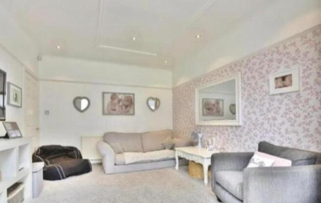 Bright lounge with floral wall and plush seatin...