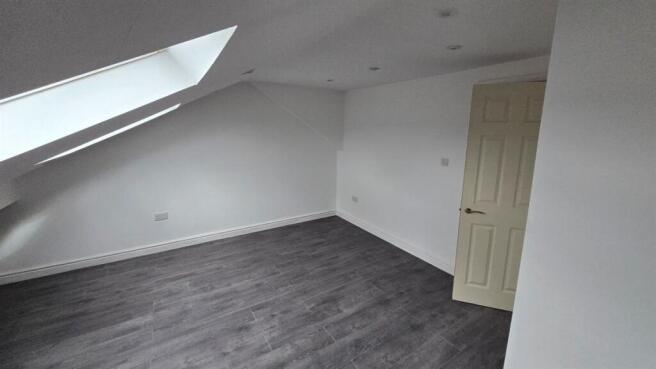 Bright attic bedroom with modern wooden floorin...