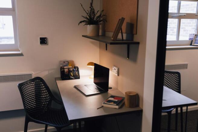 Well-lit shared workspace with a modern desk, e...