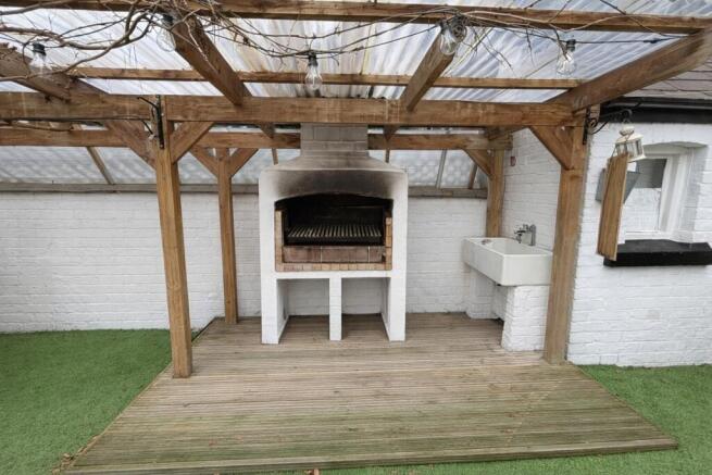Covered outdoor grilling area with a built-in b...