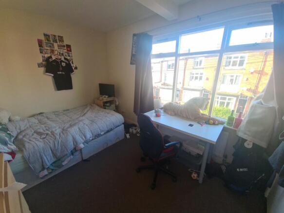 A cozy student bedroom featuring a single bed, ...