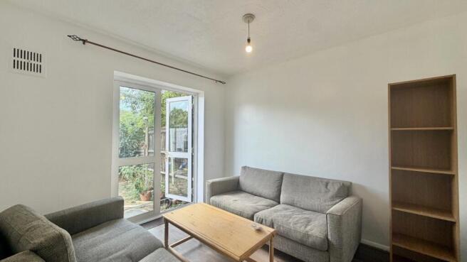 Bright living room with french doors to garden...