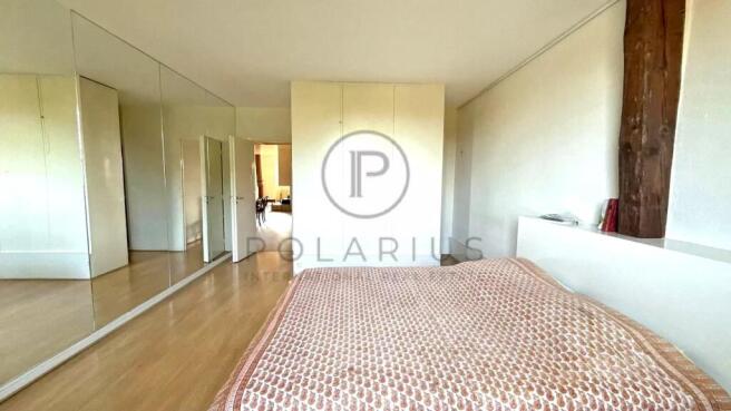 Spacious bedroom with hardwood floors and modern d