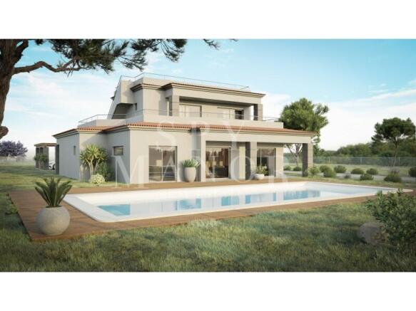 Heated swimming pool and lawn area outside a luxury detached villa in Vale del Rei, Algarve, showing the modern two-storey facade with double-glazed glass doors.