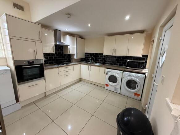 Modern fitted kitchen with cream gloss cabinets...