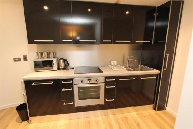 Sleek modern kitchenette with glossy cabinets...