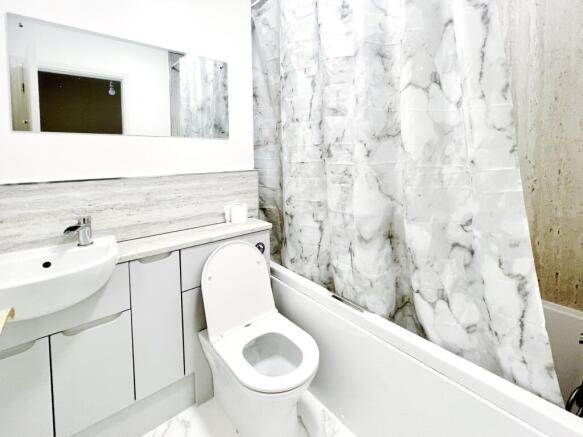 Bright, modern bathroom with a combined bath/sh...