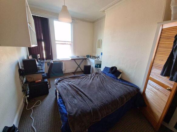 A cozy bedroom featuring a double bed with a be...