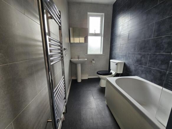 Modern bathroom featuring a clean white bath, t...