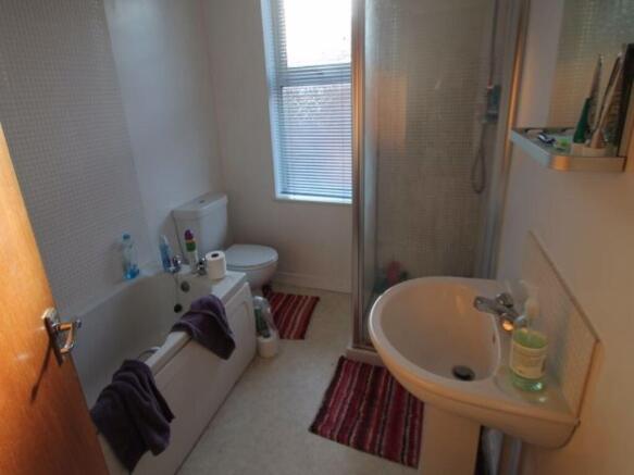 A bright and clean bathroom suite featuring a b...