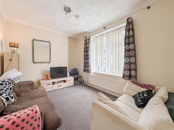 Spacious living room with large bright window...