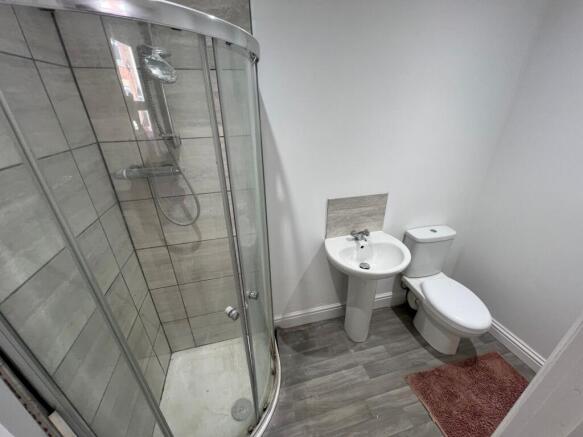 Modern bathroom featuring a curved glass shower...