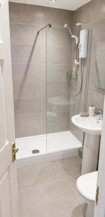 Modern tiled bathroom with a sleek glass shower...