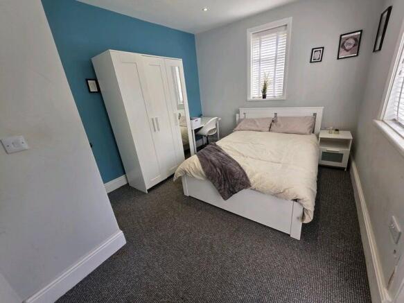 A neat and cozy double bedroom featuring a comf...