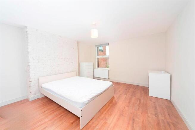 Bright, clean bedroom with wood floors...