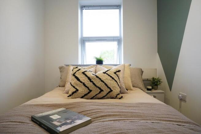 A bright and inviting master bedroom featuring ...