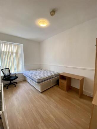 Bright double bedroom with desk and wood floors...