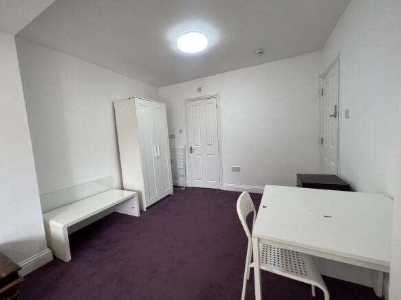 Bright, simply furnished bedroom with fresh whi...