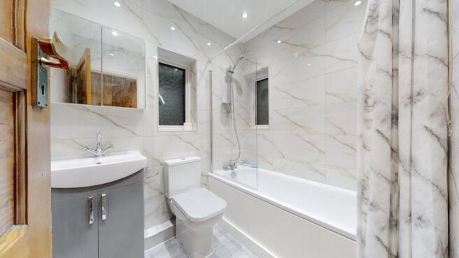 Bright, modern bathroom with a full-size bathtu...