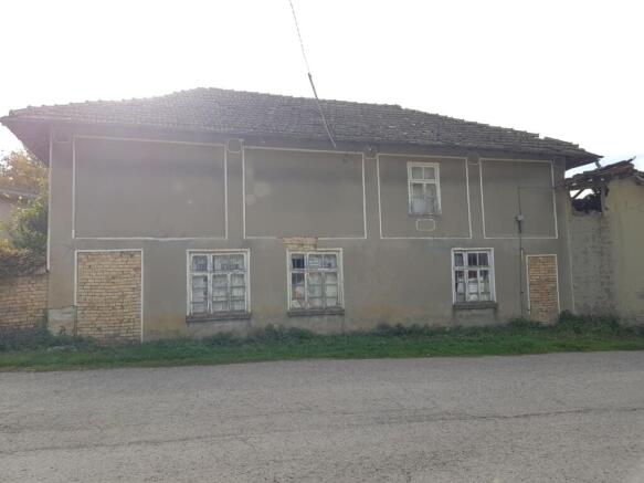 Exterior view of the two-storey house showing the front facade with three windows and a tiled roof