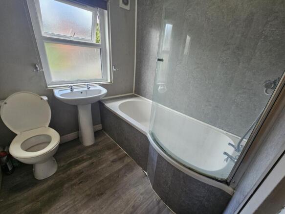 Bright, modern bathroom with a curved shower-ba...