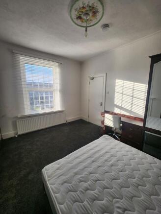 Bright, uncluttered bedroom with a large sash w...