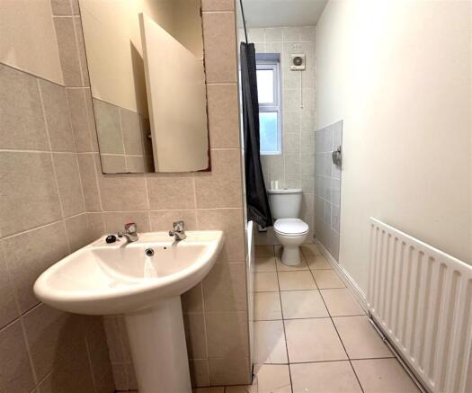 Bright bathroom with neutral tiling and window....