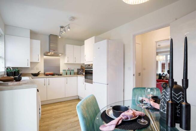 A modern, minimalist kitchen with white cabinets, stainless steel appliances