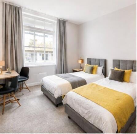 Bright bedroom with dual beds and study space...