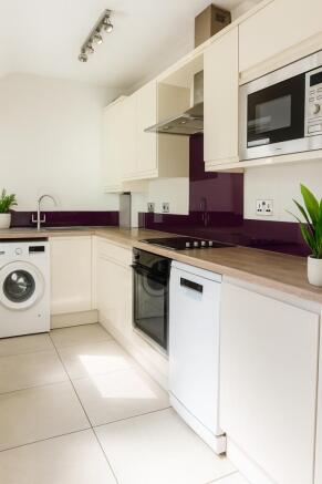 Bright modern kitchen with sleek cream cabinetr...