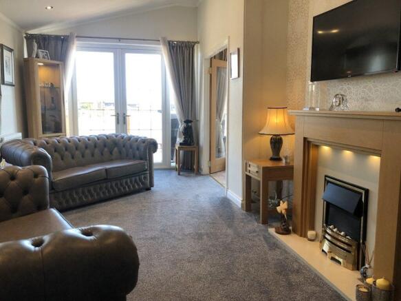 Spacious Lounge With Leather Sofas And Fireplace