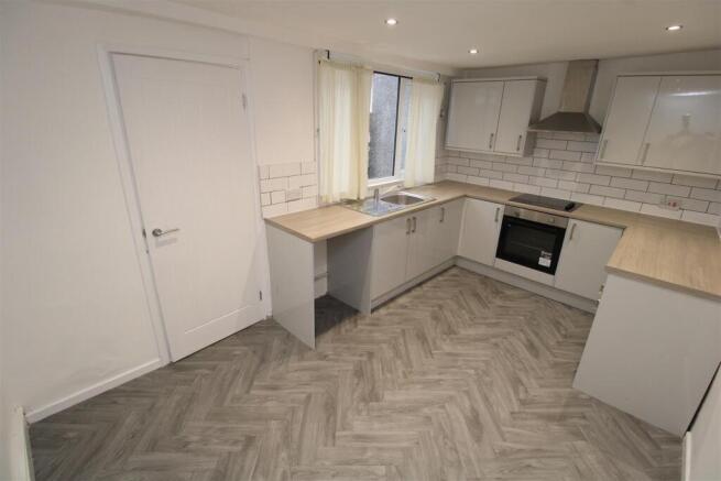 Modern kitchen with chic herringbone flooring...