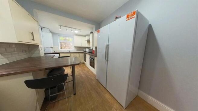 Bright, modern galley kitchen with integrated a...