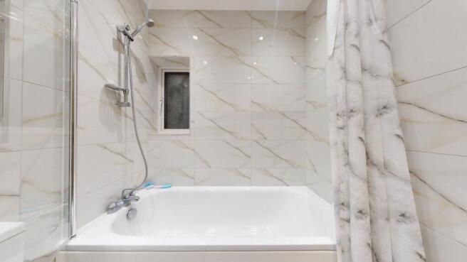 Bright, modern bathroom with a full-size bathtu...