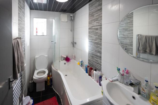 A modern bathroom suite featuring a curved bath...