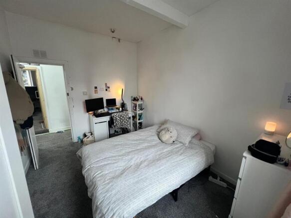 Bright bedroom featuring a cozy study area...