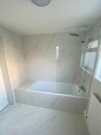 A modern and clean bathroom featuring a bath an...
