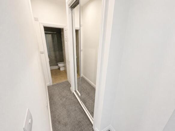 Bright hallway with built-in mirrored storage...