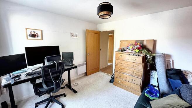 A spacious, well-lit living room featuring a de...