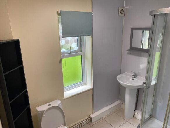 A practical bathroom featuring a small sink, to...