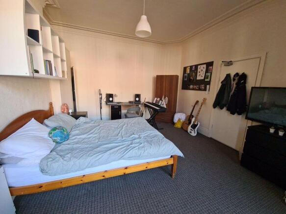 Spacious master bedroom featuring a double bed,...