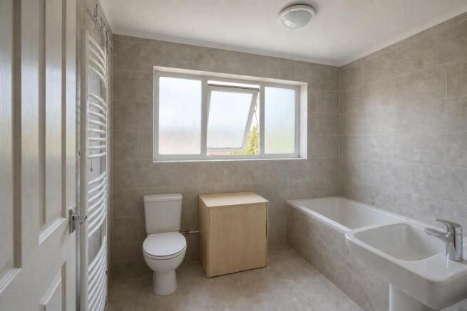 Bright bathroom with bath and heated towel rail...