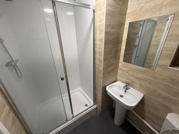 Modern tiled bathroom with a walk-in shower, pe...