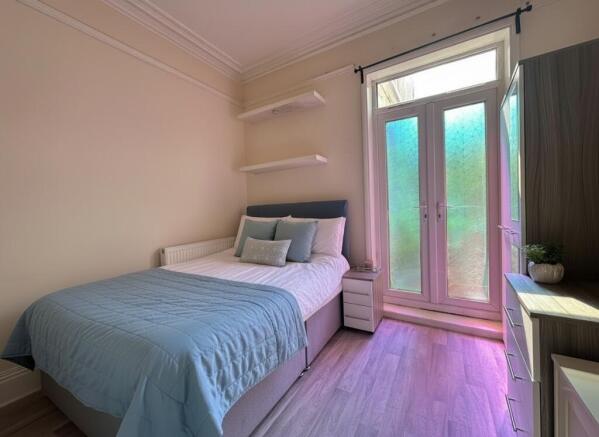 Bright bedroom with stylish decor and patio doo...