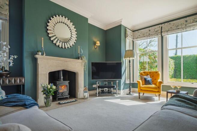 Multifuel log burner set within stone fireplace